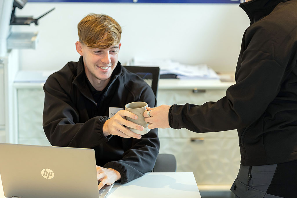 Installer passing other installer mug.