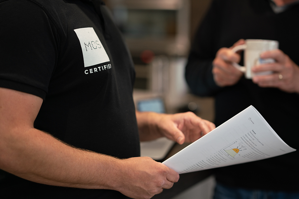 Man holding paper with MCS branded polo on.