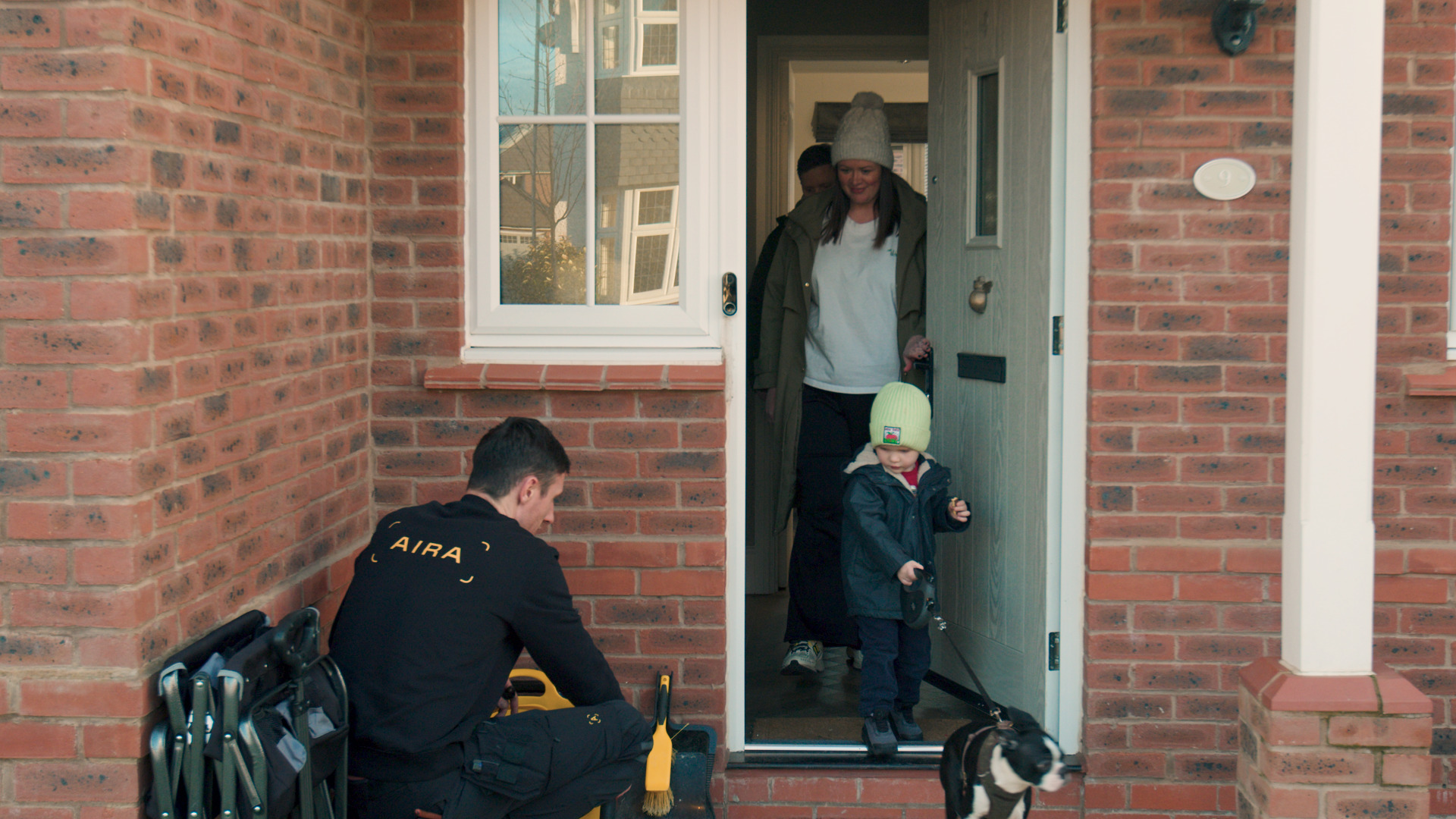 Mother and son on door step with installer.