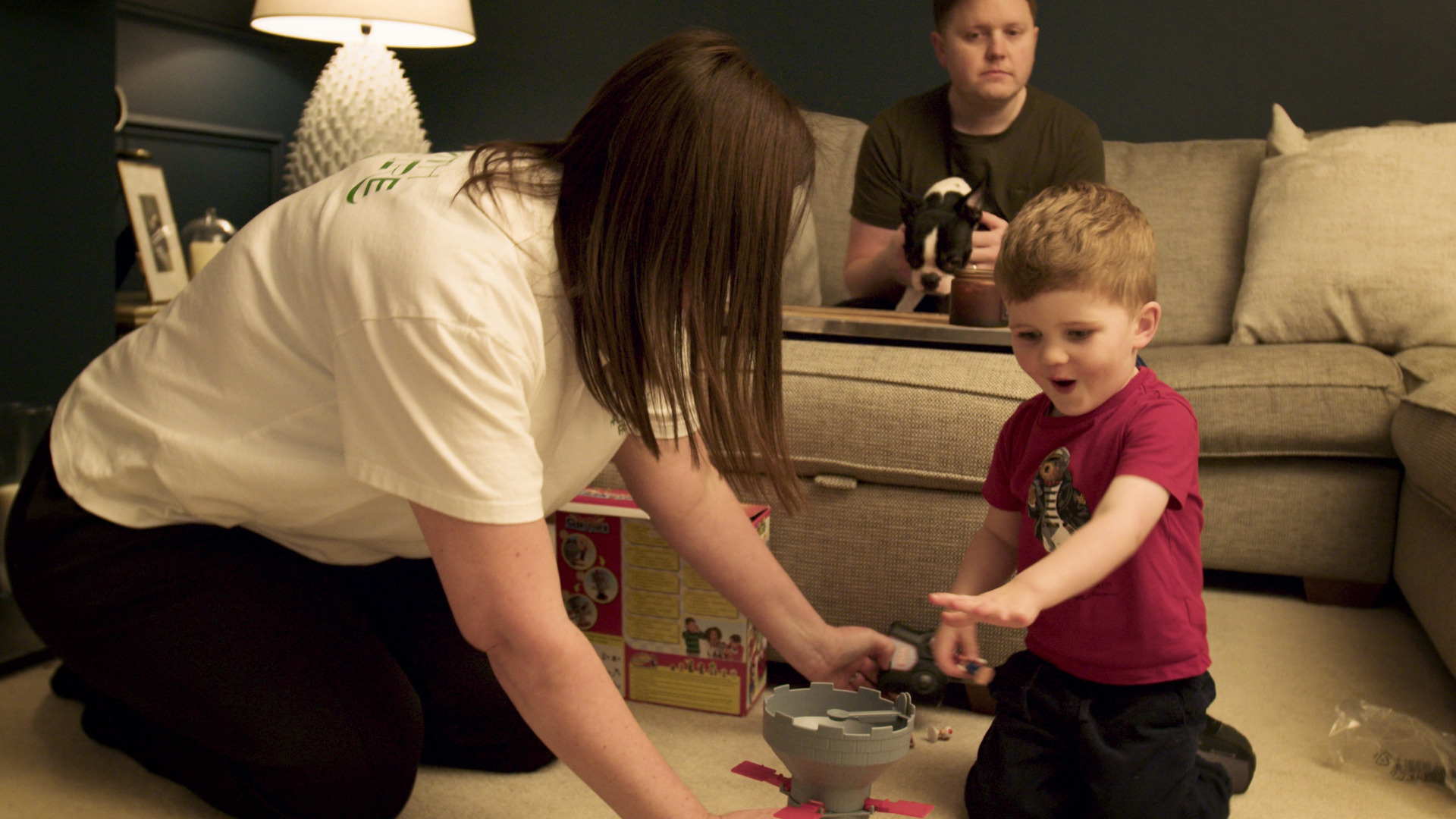 Family sat playing in living room.