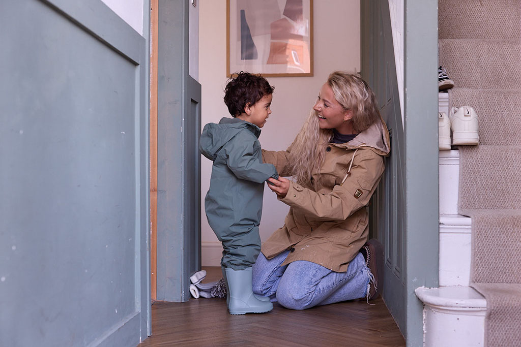 Mother getting her son ready to go outside.