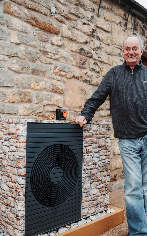 Man stood next to heat pump.
