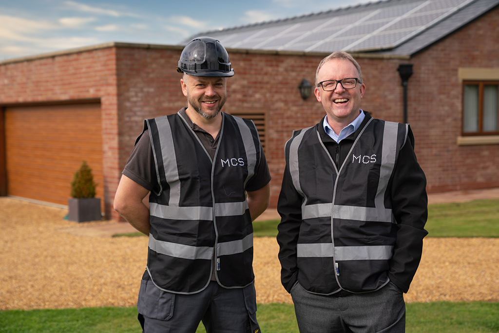 MCS CEO Ian Rippin and installer stood posing wearing MCS hivis jackets.