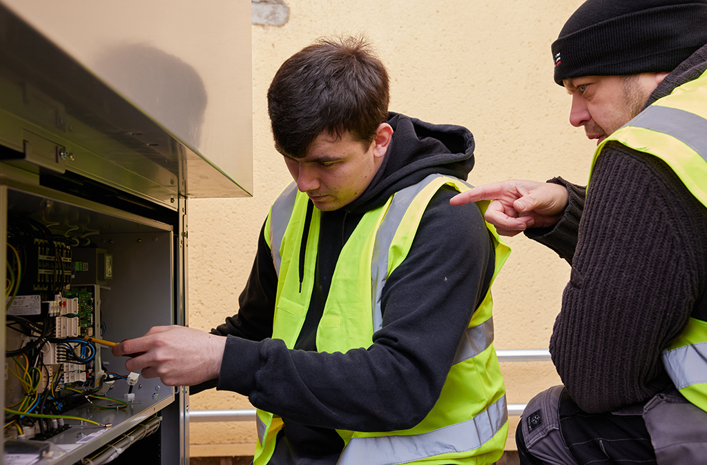 Apprentice working on heat pump with mentor