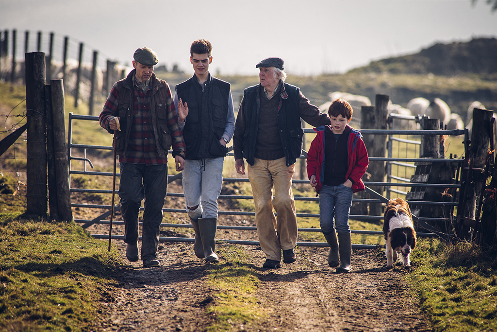 Family walking on farm with a dog.