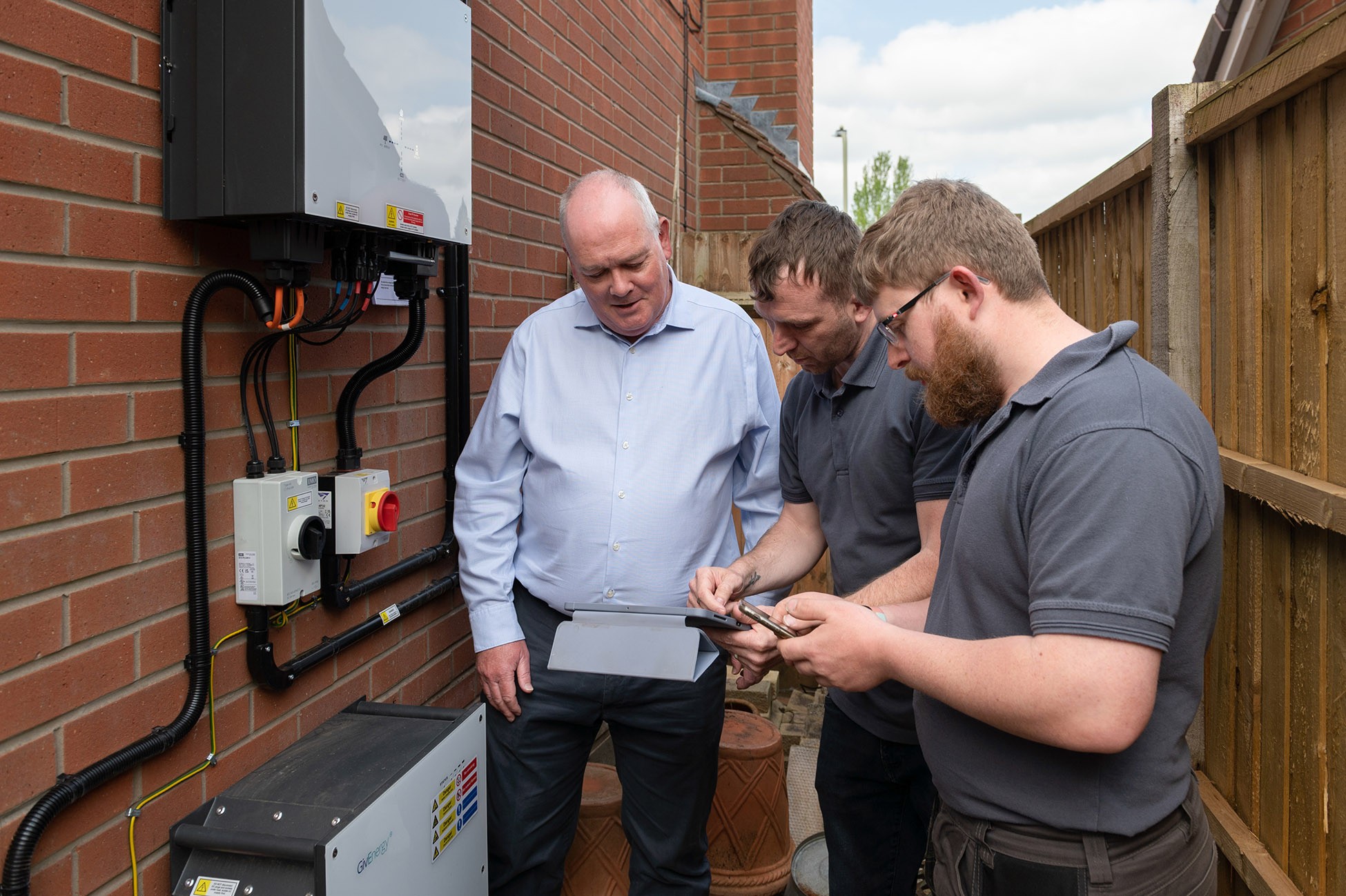 Installers and homeowner, with battery storage system.