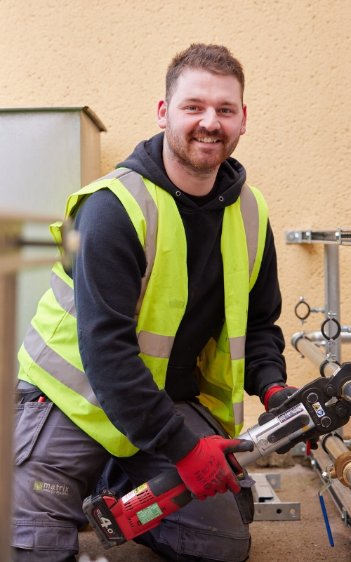 Installer smiling at camera in hi-vis.