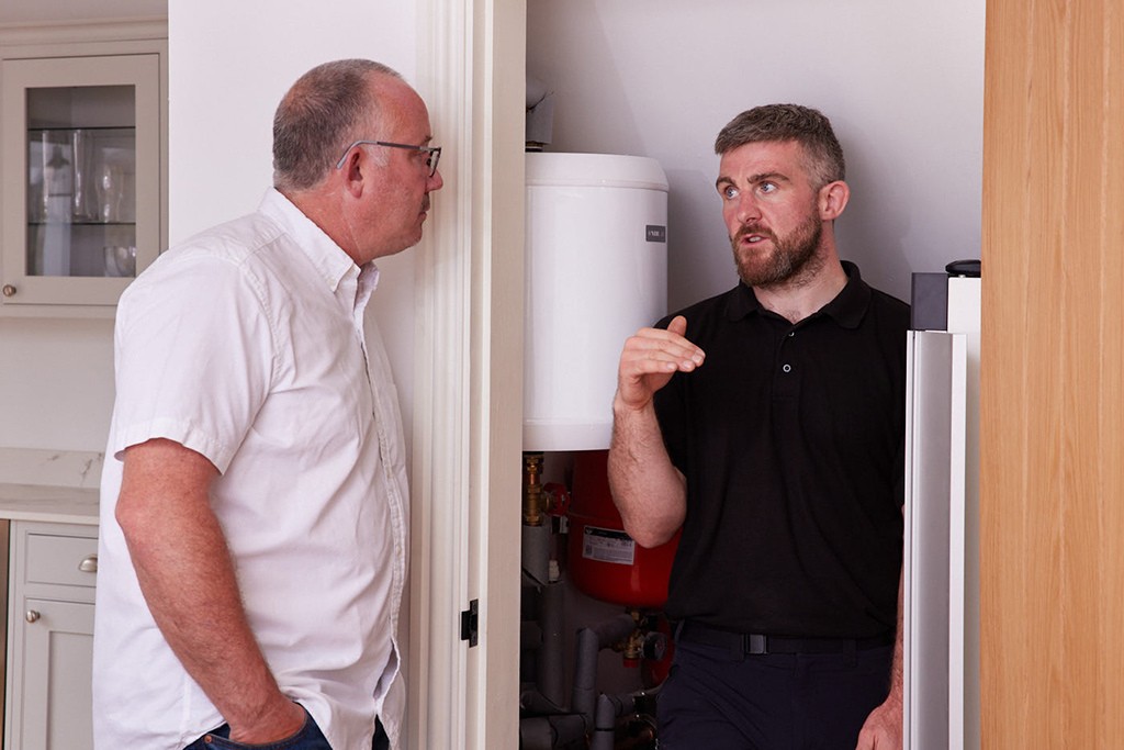 Installer and homeowner with water tank.
