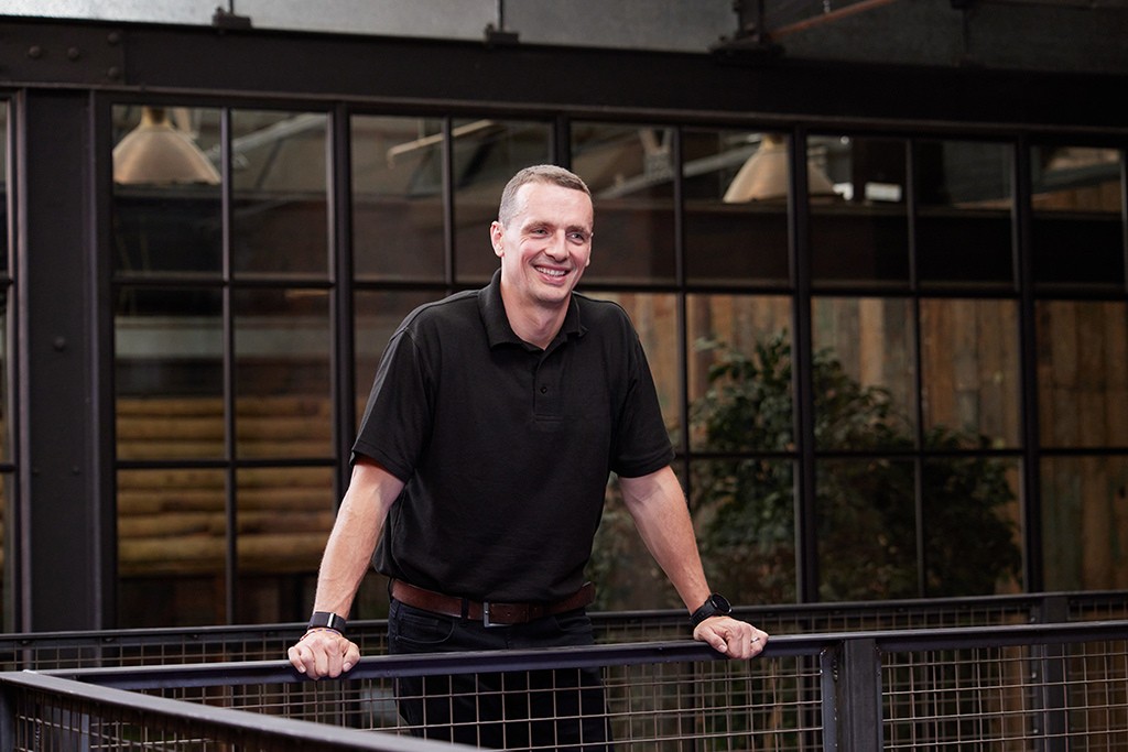 Installer stood holding banister smiling.